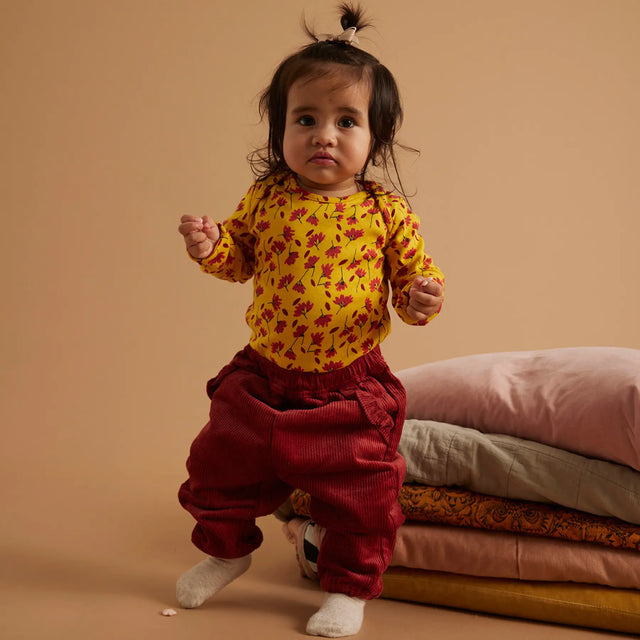 Baby iført Soft Gallery Bob Winterflower body i Old Gold.