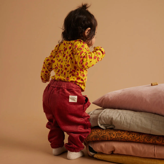 Baby iført Soft Gallery Bob Winterflower body i Old Gold.