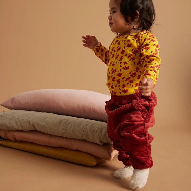 Baby iført Soft Gallery Bob Winterflower body i Old Gold.