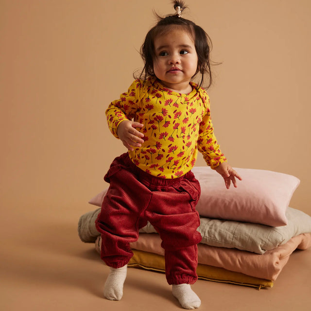 Baby iført Soft Gallery Bob Winterflower body i Old Gold.